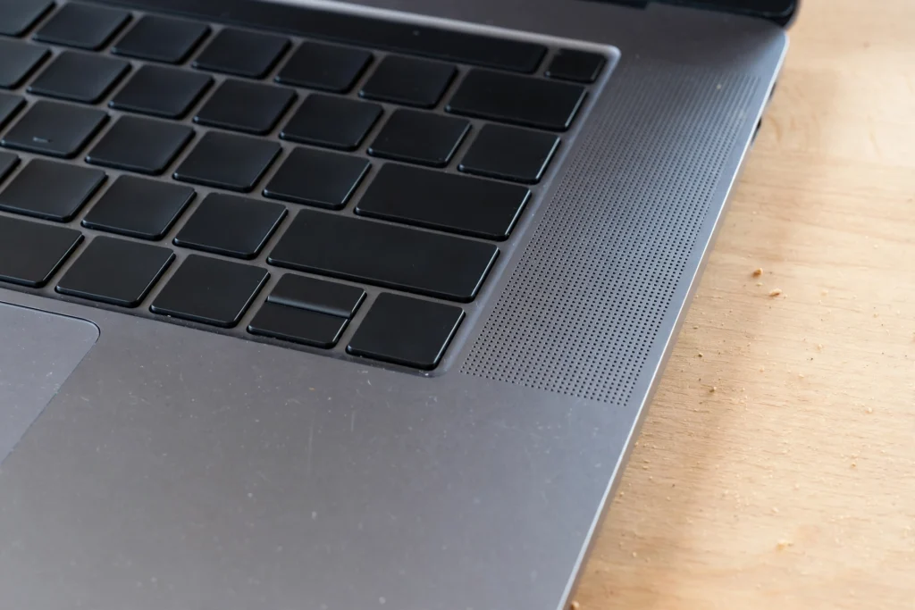 Close-up of a laptop speaker grille where laptop speakers crackling can be heard during playback